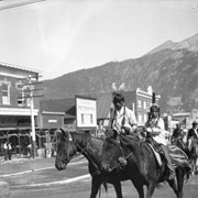 Cover image of Unknown people in regalia on horseback, Banff Indian Days parade on Banff Avenue
